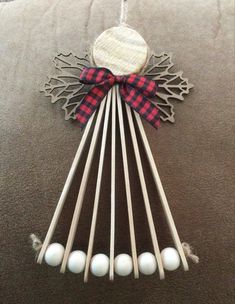 a christmas ornament made out of wood sticks and white balls