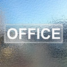 a frosted glass window with the word office written on it in white letters, against a blue sky background