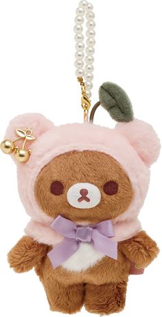 a brown teddy bear wearing a pink outfit with pearls on it's neck and a green leaf hanging from the back