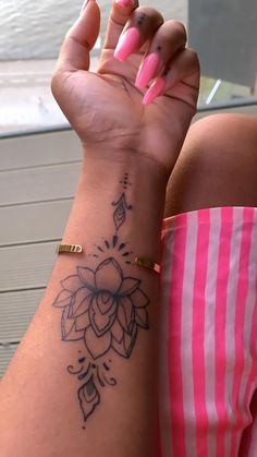 a woman's arm with a flower tattoo on the left side of her wrist