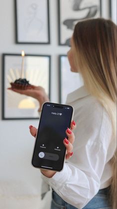 a woman holding up a cell phone in her hand