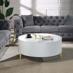 a living room with two couches and a round coffee table in the middle of it