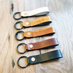 four pairs of scissors sitting on top of a wooden table next to eachother