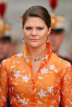 a woman in an orange dress with flowers on it