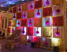 a chair sitting in front of a wall decorated with flowers and balls on it's side