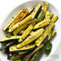 grilled zucchini on a white plate garnished with parsley