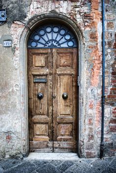 an old wooden door is open in front of a brick wall and stone doorways