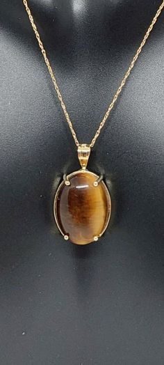 TIGER EYE Pendant / Necklace /Charm in 14k Yellow Gold 18 Inches Rope Chain. 14k Yellow Gold Oval Tiger's eye Pendant. Real Oval Tiger's eye Stone. Product Info: -Stone: Tiger's eye. -Metal: 14k Yellow Gold. -Pendant Measures: 21 x 12mm. -Tiger's eye Measures: 16x11mm -Tiger's eye Carat: 1.34 -Chain length: 18 Rope Inches. -Made in USA. -Nice Gift Box Included. Tigers Eye Pendant, Tigers Eye Jewelry, Tiger Eye Necklace, Tiger Jewelry, Birthday Stone, Tiger Necklace, Caged Necklace, Gold Tiger Eye, Tigers Eye Necklace