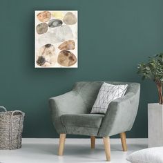 a living room with green walls and a grey chair in the corner next to a potted plant