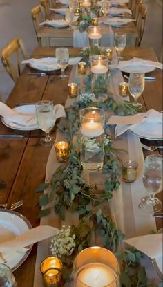 a long table is set with candles and greenery