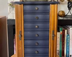 a tall wooden cabinet with many drawers and knobs on the front, sitting next to a bookshelf