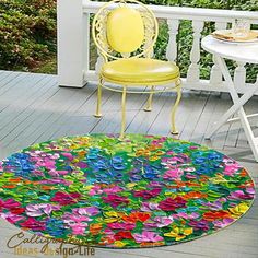 a chair and table on a porch with flowers in the middle of the floor area