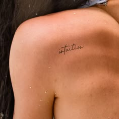 the back of a woman's shoulder with an inscription on it that says attraction