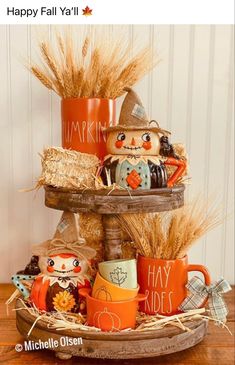 there is a three tiered tray with coffee mugs and scarecrows on it