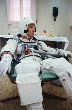 an astronaut sitting in a chair with his foot on the ground