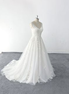 a white wedding dress on a mannequin in front of a white wall and floor