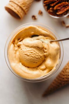 an ice cream sundae with pecans in the background