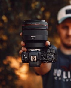 a man holding up a camera in front of his face with the lens attached to it