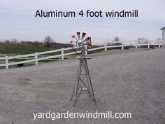 a windmill sitting in the middle of a dirt field