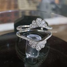 a diamond ring sitting on top of a glass display case in front of a black table