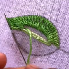 someone is cutting grass with scissors on a piece of cloth that has been stitched together