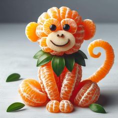 an orange monkey made out of fruit with leaves on it's back and eyes