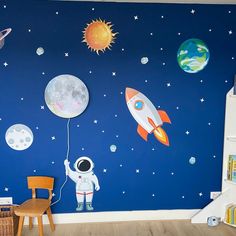 a child's room with an astronaut mural on the wall