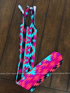 a pair of pink and blue patterned leggings sitting on top of a wooden floor