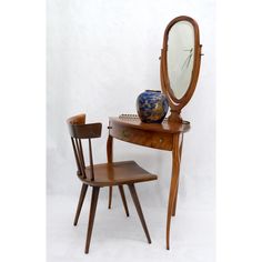 a wooden desk with mirror and chair in front of white background, showing reflection of vase on table