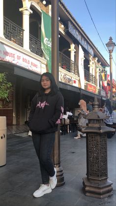 a woman standing next to a lamp post