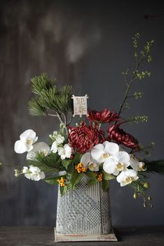 a vase filled with white and red flowers