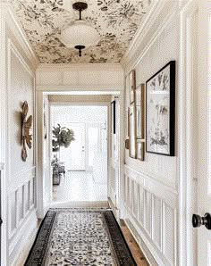 the hallway is decorated in white and black with floral designs on the ceiling, along with an ornate rug