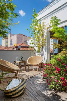 two wicker chairs sitting on top of a wooden deck