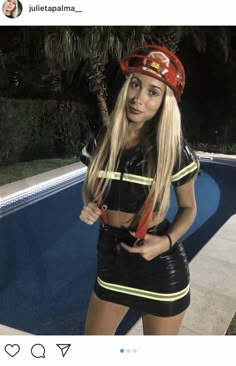 a woman wearing a fireman's hat and skirt standing in front of a swimming pool