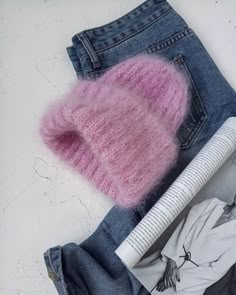 a pair of jeans and a pink knitted hat