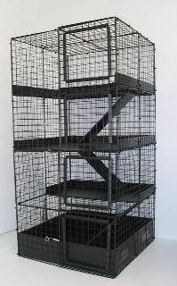 a black cage with stairs on the top and bottom is shown in front of a white wall