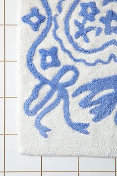 a blue and white bathroom rug with the word love written in cursive writing