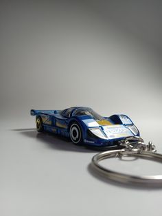 a keychain with a blue race car on it sitting next to a pair of scissors