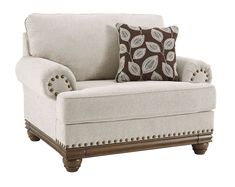 a white chair with a brown pillow on it's back and two pillows on the armrests