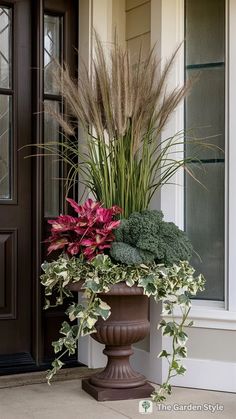 a planter filled with lots of flowers next to a door