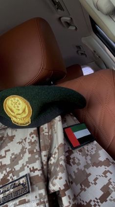 an army uniform is sitting in the back seat of a car with other items on it