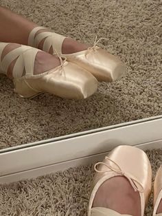 a pair of ballet shoes sitting in front of a mirror