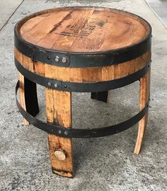 a wooden barrel coffee table sitting on top of a cement floor next to a sidewalk