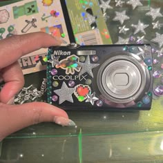 a person holding a camera in front of a table with other items on it,