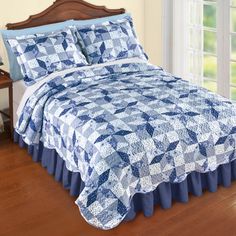 a blue and white quilted bed in a bedroom