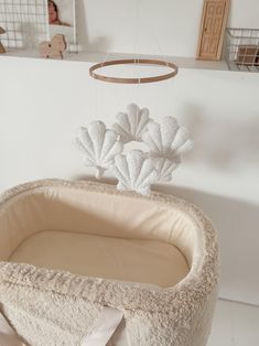 Seashell mobile Our best-selling boucle mobile just got an upgrade, meet our new nursery decoration, the seashell mobile. This is top-tier craftsmanship, with each mobile lovingly and delicately handmade in Yorkshire. Perfect for a neutral space, this decorative nursery accessory is made from luxury, textured micro boucle fabric in ecru. Watch as the shells dance away above your little one's head as they fall asleep. Complete the set with our seashell cushion and boucle moon cushion. Material: 100% polyester micro boucle / cotton string / Hoop: 100% FSC sustainable beech wood Stuffing: Super carded hollow fibre polyester / Safety: CE & BS5852 Measurements: Shell approx. 13cm x 13cm  Wood hoop: 20cm (lowest hanging mobile piece falls about 27cm from hoop) Please note:  There is a loop at th Surfer Nursery, Seashell Mobile, Ocean Nursery Decor, Wooden Cribs, Neutral Nursery Decor, Shell Mobile, Florida Art, Nursery Decor Neutral