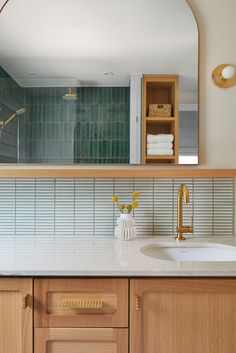 a bathroom sink with a mirror above it and wooden cabinets in front of the sink