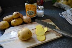 potatoes are cut up on a cutting board next to a knife and bottle of olive oil