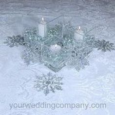 three candles sitting on top of a table covered in snow