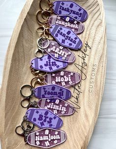 six keychains with purple and white designs are on a wooden tray that says, i love my mom